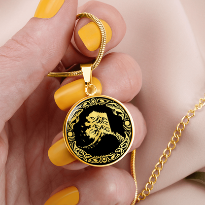 Gold finish Alaska mountain necklace with dramatic snowy peak illustration, black and gold linocut design and decorative border.