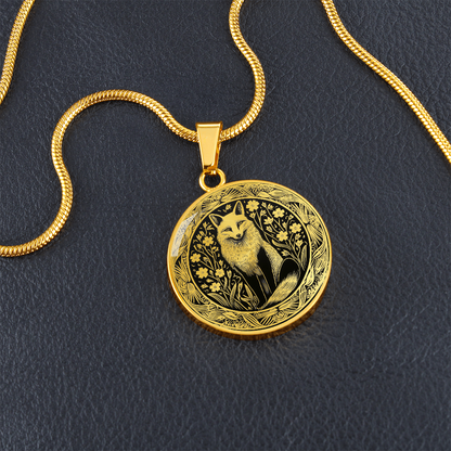 Gold finish woodland fox necklace featuring intricate black-and-white fox artwork on a circular pendant with blu leather background
