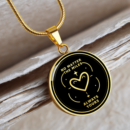 18K gold finish No Matter the Miles pendant with gold heart illustration, decorative stars and Always Yours lettering on black.