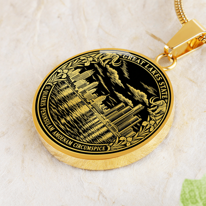 Gold finish Detroit skyline pendant with black and gold cityscape, botanical border, Great Lakes State inscription and Latin motto