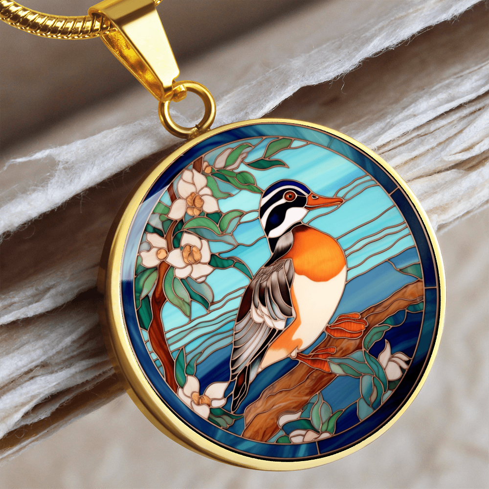Gold Mandarin duck-inspired necklace featuring a colorful duck perched on a flowering branch against a turquoise-blue stained-glass-style background.