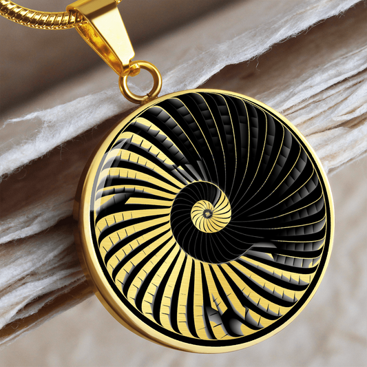 Black and gold spiral staircase necklace featuring curved geometric steps winding into an optical illusion at the center of a round pendant.