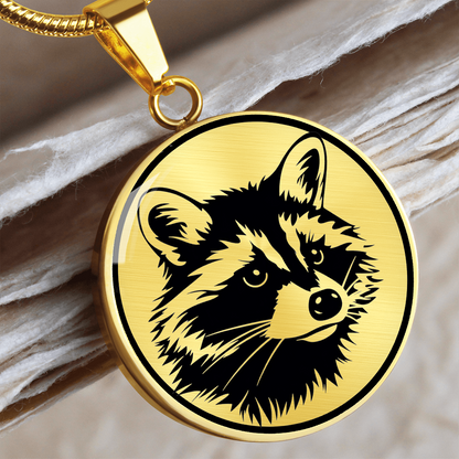 Raccoon necklace featuring a bold black-and-white raccoon face illustration with pointed ears and distinctive eye mask on a round silver-colored pendant.