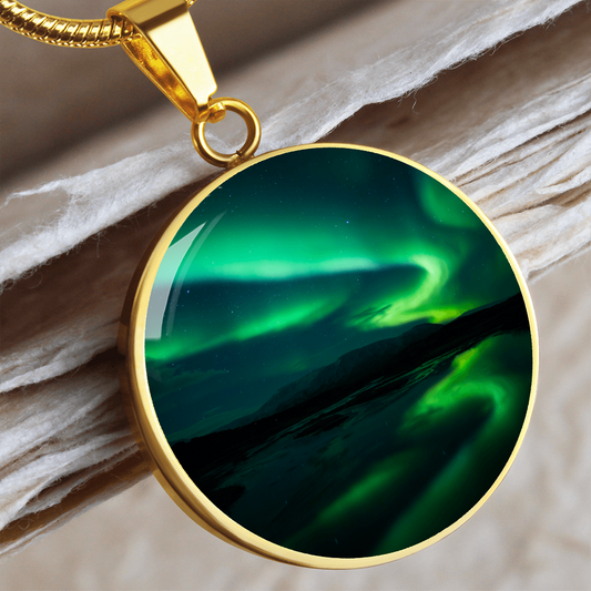 Green Aurora Northern Lights necklace featuring vivid emerald aurora ribbons above dark mountains on a round silver-colored pendant.