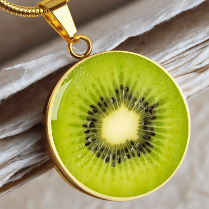 Kiwi fruit necklace featuring a vivid green kiwi slice with black seeds and pale center on a round silver-colored pendant.