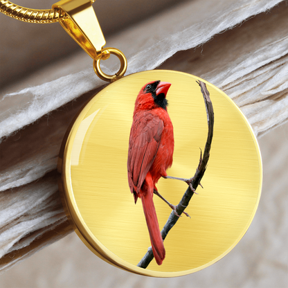 Realistic Northern Cardinal necklace showing a bright red male cardinal with black facial mask perched on a branch on a round pendant.
