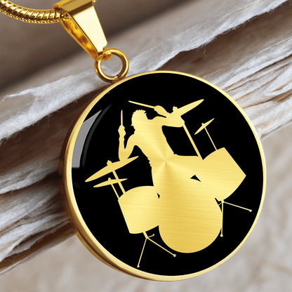 Drum kit necklace featuring a silver drummer silhouette playing an acoustic drum set against a black circular pendant background.