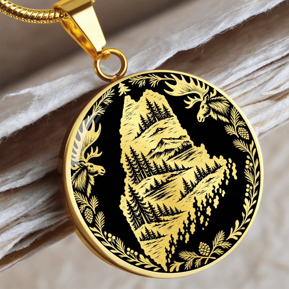 gold Maine moose necklace featuring Maine state outline with mountain forest landscape, two moose and pinecone woodland border