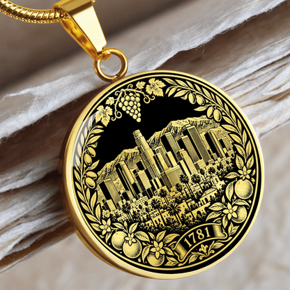 Gold Los Angeles skyline necklace featuring downtown skyscrapers, palm trees, mountains, citrus fruit and 1781 botanical emblem