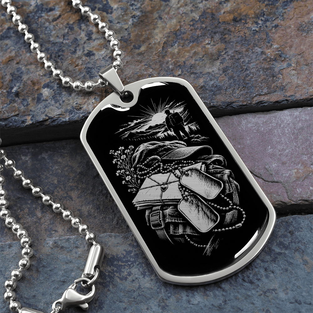 Polished silver military deployment dog tag with white-on-black illustration of letters, backpack, dog tags and distant walking figure.