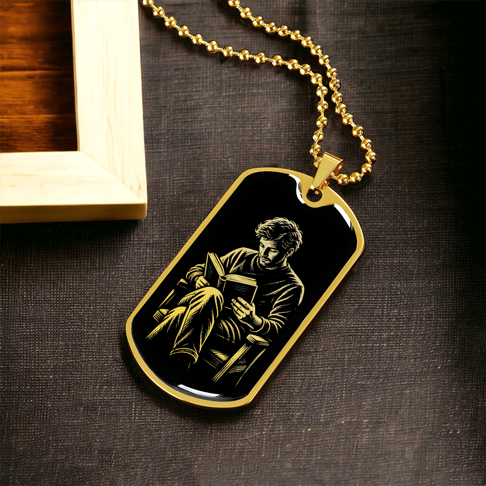 Gold finish reading dog tag necklace featuring gold-toned illustration of a seated man reading against black.