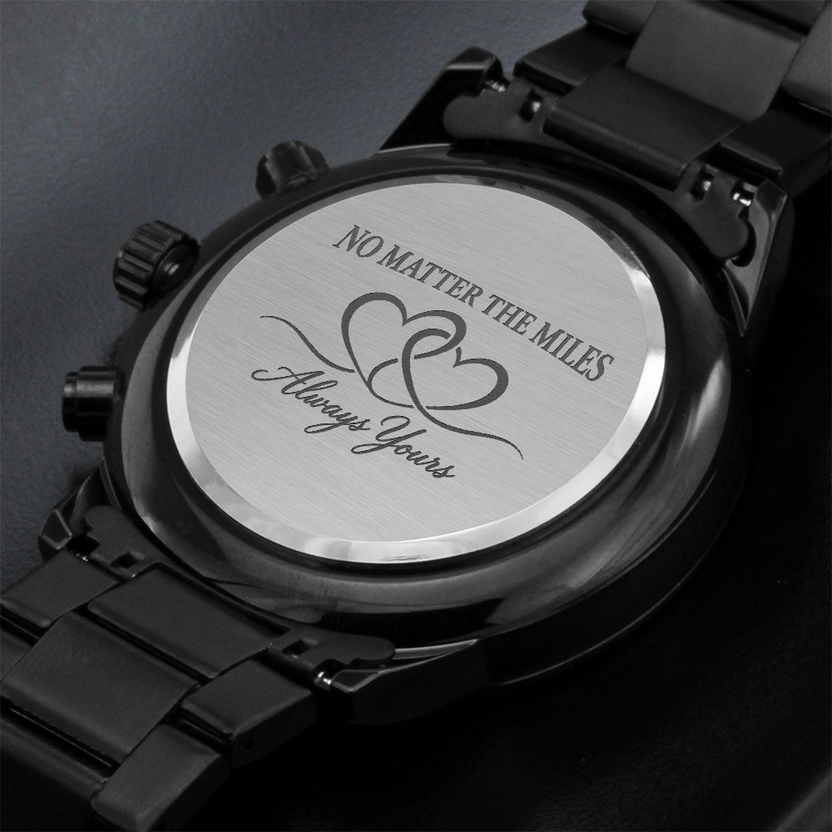 Close-up of watch case back with intertwined hearts and engraved words No Matter the Miles Always Yours