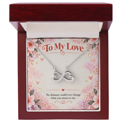 14K white gold finish infinity hearts necklace on pink floral card reading No distance could ever change what you mean to me.