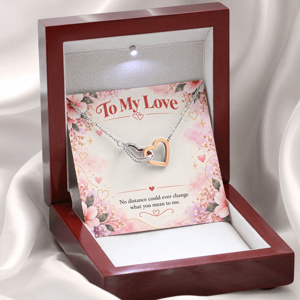 Interlocking hearts necklace featuring overlapping silver and rose gold open-heart pendants with sparkling cubic zirconia crystals.