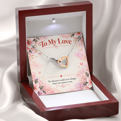 Interlocking hearts necklace featuring overlapping silver and rose gold open-heart pendants with sparkling cubic zirconia crystals.