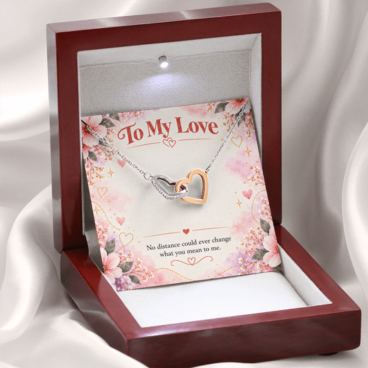 Interlocking hearts necklace featuring overlapping silver and rose gold open-heart pendants with sparkling cubic zirconia crystals.