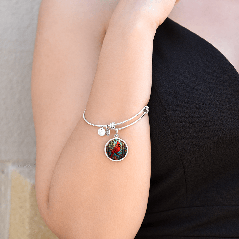 Red cardinal bracelet worn on wrist with circular bird charm