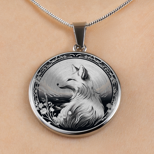 A round silver pendant necklace featuring a detailed black and white illustration of a fox, displayed on a person's skin with a silver chain visible at the top.