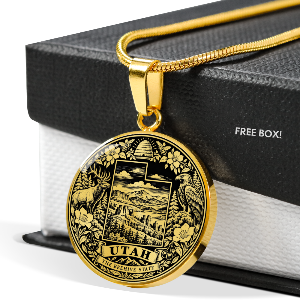 A gold-toned Utah state seal pendant necklace displayed on a black gift box with the text 'FREE BOX!' visible on the side.
